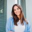 Happy caucasian young student female looking at camera enjoying with a perfect white teeth. Portrait of a joyful and adorable teenage brunette woman posing for a college promotion with crossed arms. High quality photo