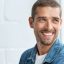 Confident young man looking away with big smile. Happy handsome guy looking through window thinking about the future. Closeup face of smiling casual man imagine with copy space.